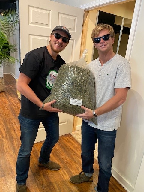 L-R: Henry Moen and Michael Chosewood pose with a bag of Avaloo hemp product in 2021